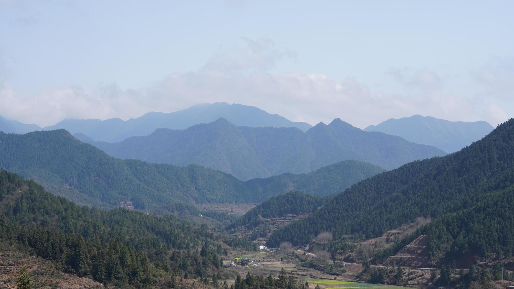 The beautiful mountains view with the green forest and flowers field in the countryside of the southern China photo