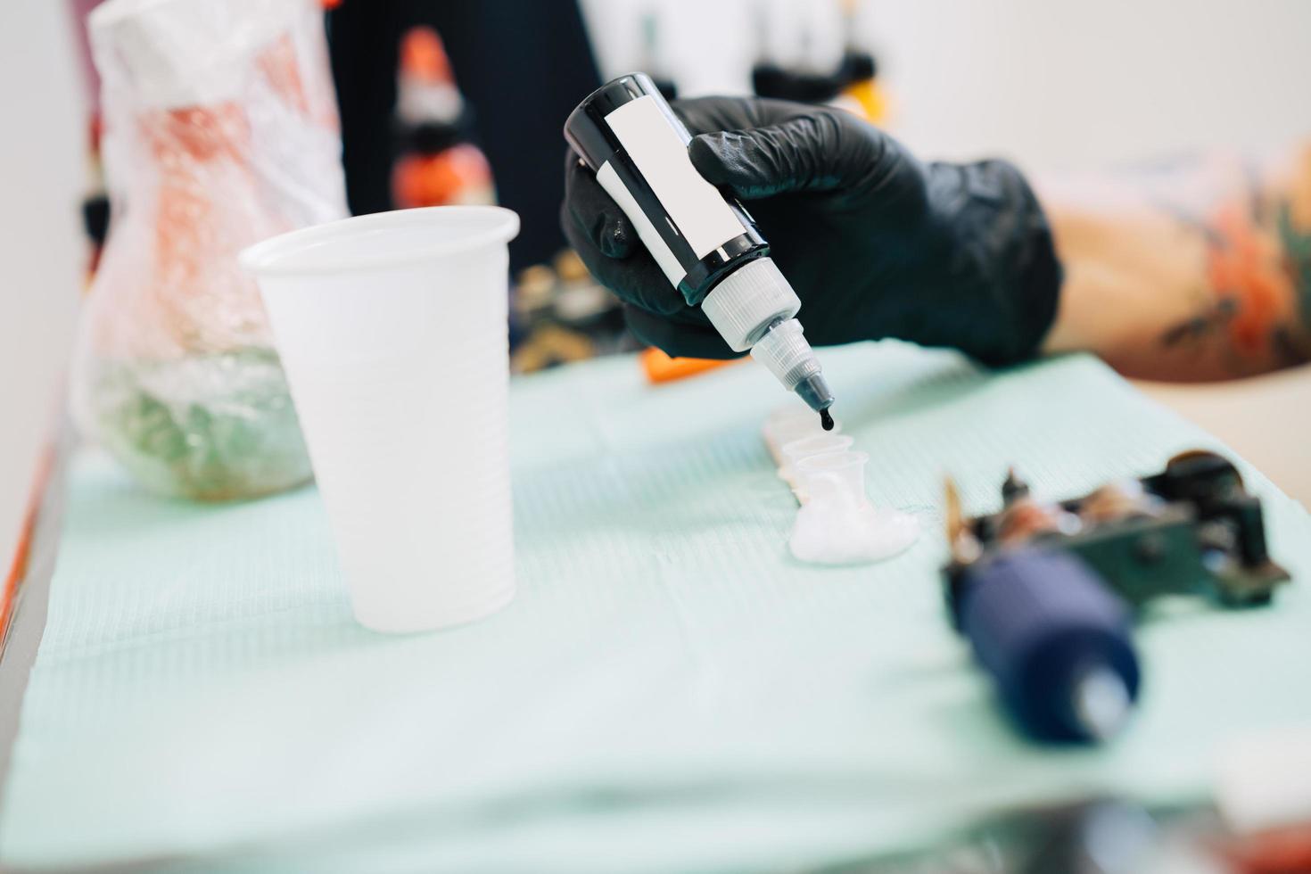 Female tattooist preparing the dyes she's going to work with. photo