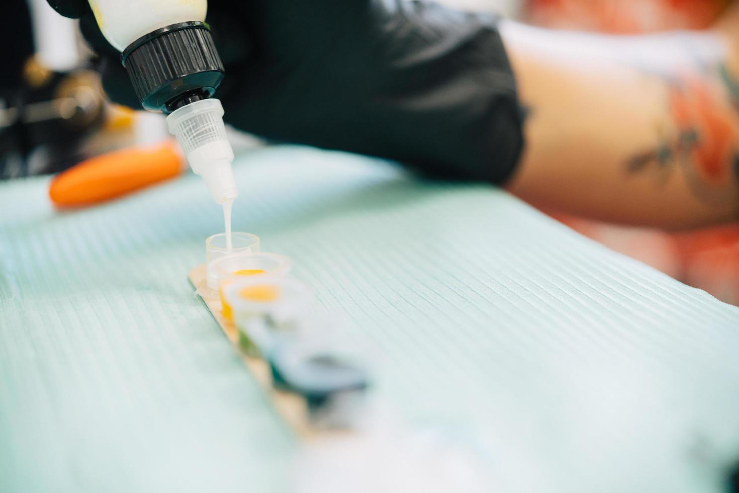 Female tattooist preparing the dyes she's going to work with. photo