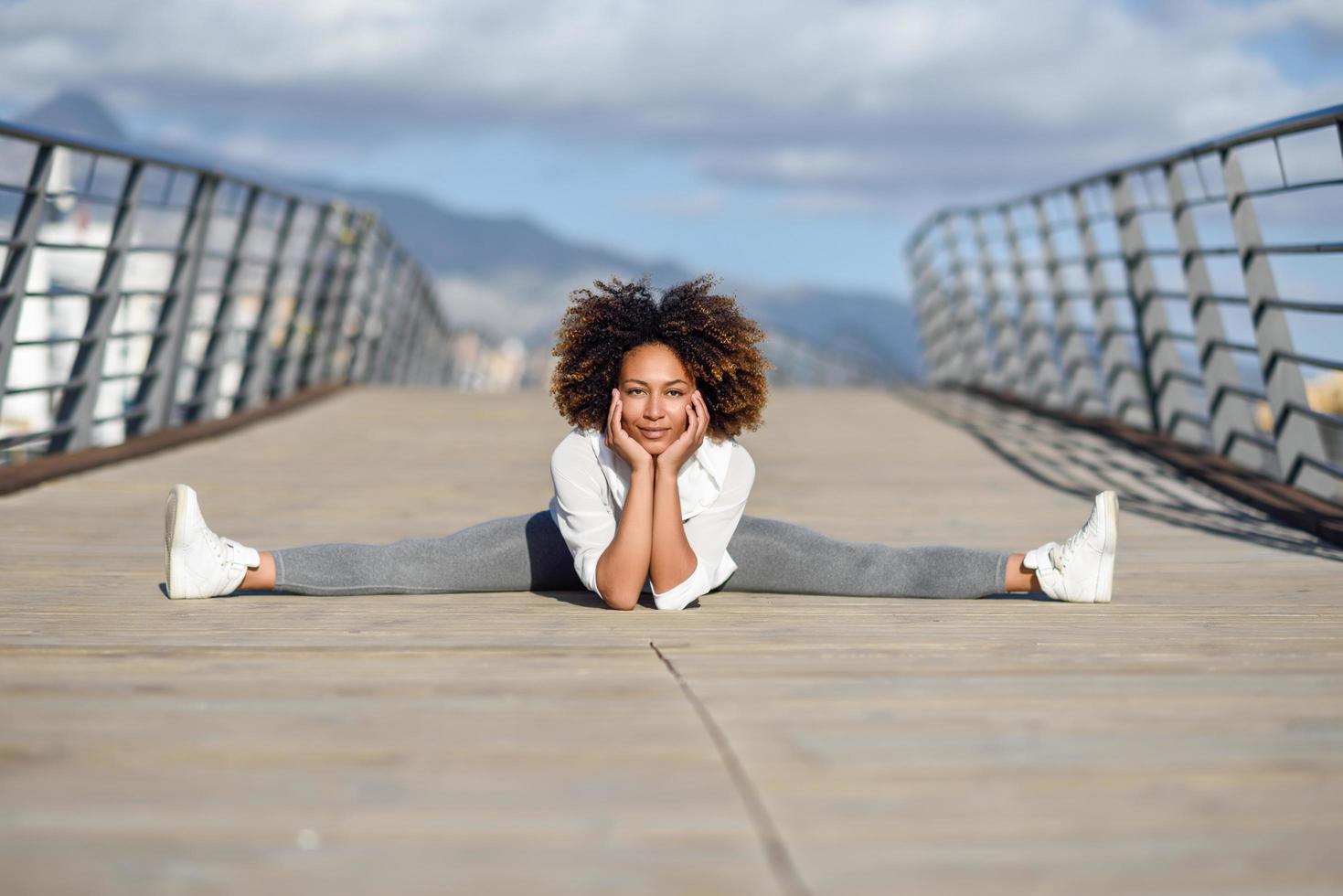 Young black woman doing stretching after running outdoors photo