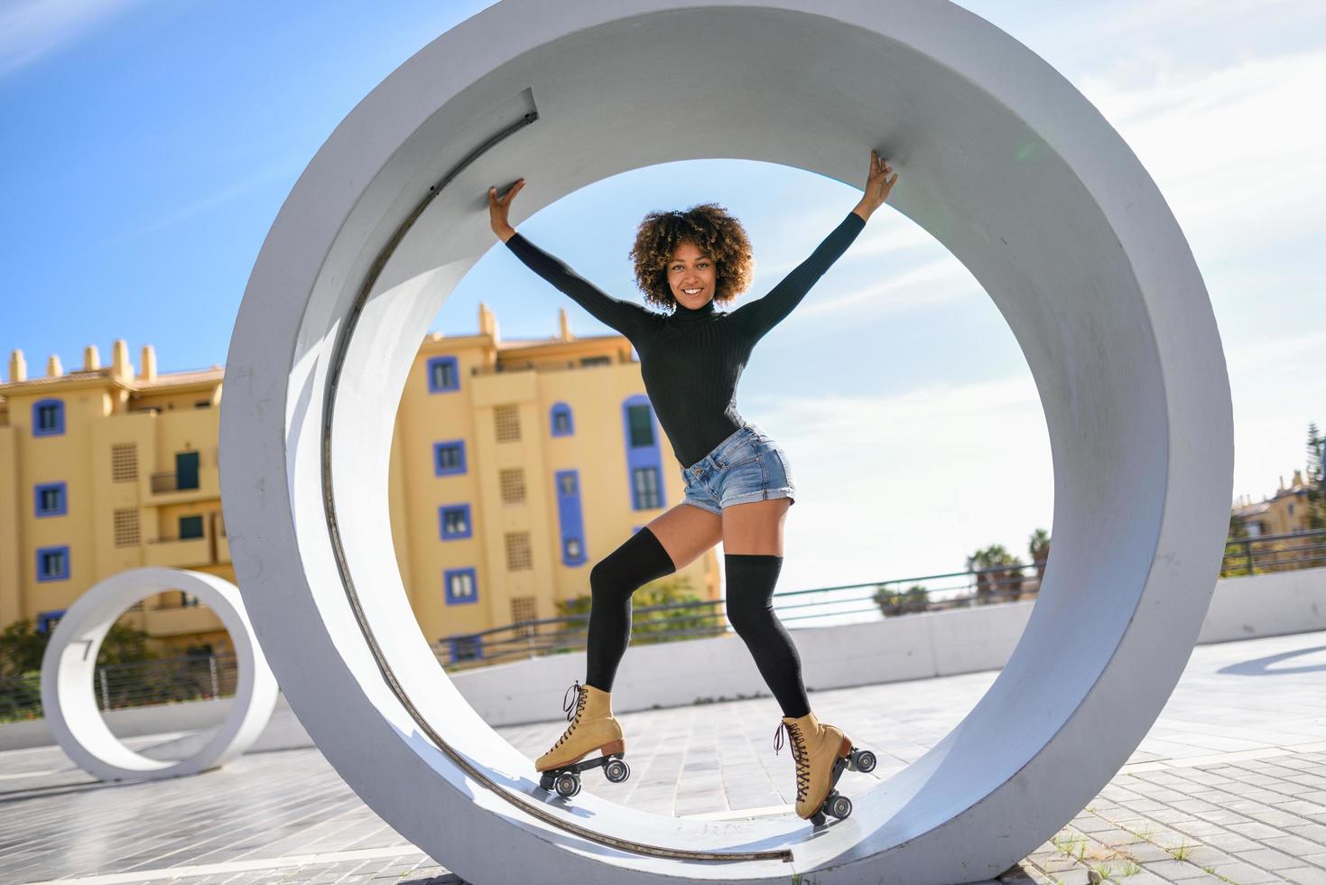Black woman on roller skates riding outdoors on urban street photo