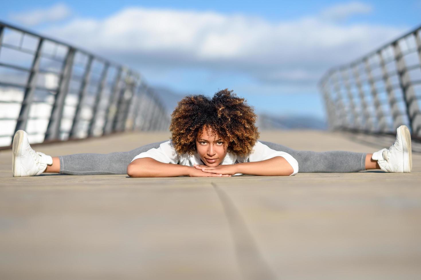 Young black woman doing stretching after running outdoors photo