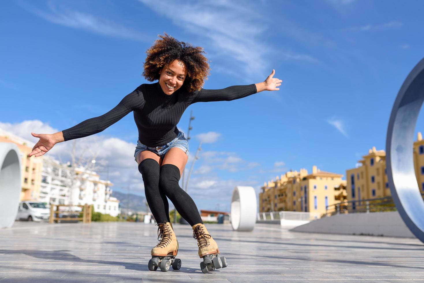 mujer negra, en, patines, equitación, aire libre, en, urbano, calle foto