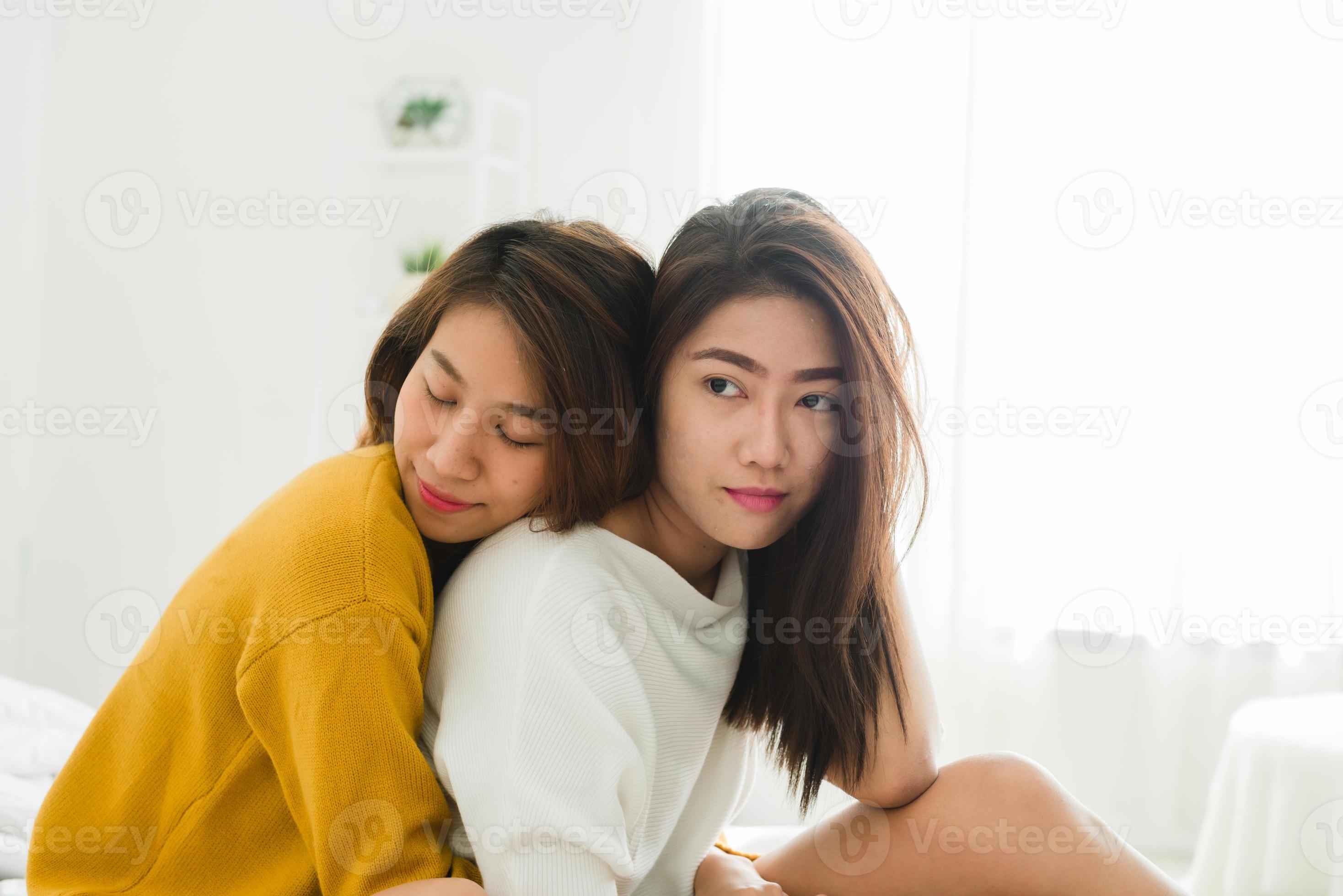 Beautiful young asian women LGBT lesbian happy couple sitting on bed hugging and smiling together in bedroom at home. LGBT lesbian couple together indoors concept pic