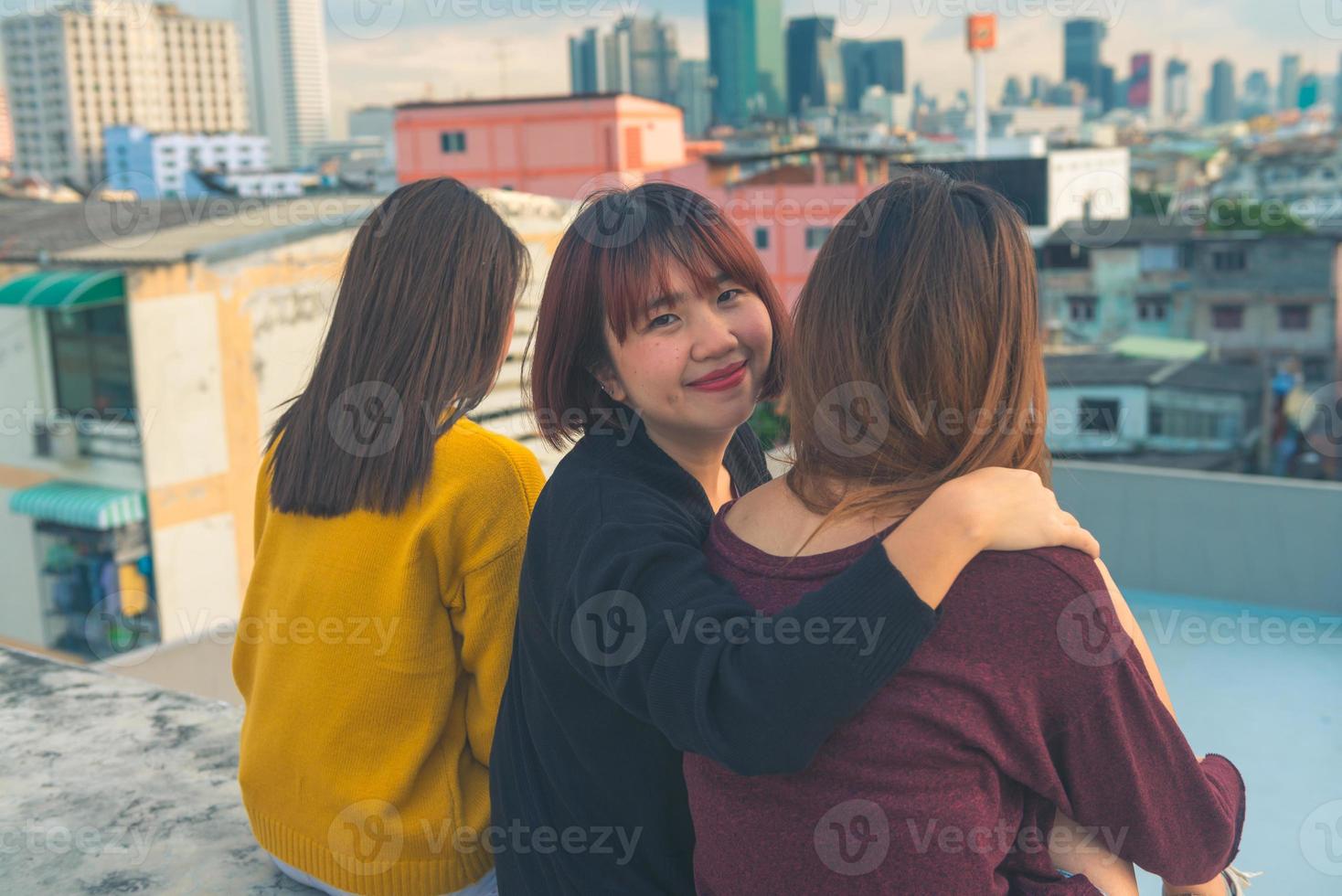 Feliz grupo de amigas asiáticas disfrutan y se relajan en la fiesta en la azotea al atardecer, celebración festiva, estilo de vida adolescente, libertad y diversión foto