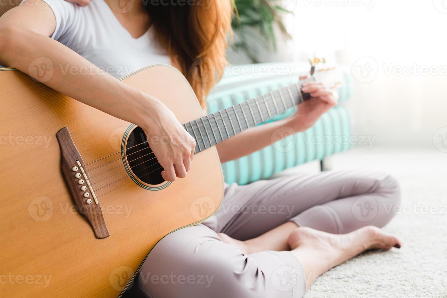 Pareja de lesbianas jóvenes asiáticas tocando la guitarra para su amante con un momento de amor en el dormitorio rodeado de la cálida luz del sol. pareja lgbt tiene un momento de amor juntos en la cama. concepto de momento de amor lgbt. foto