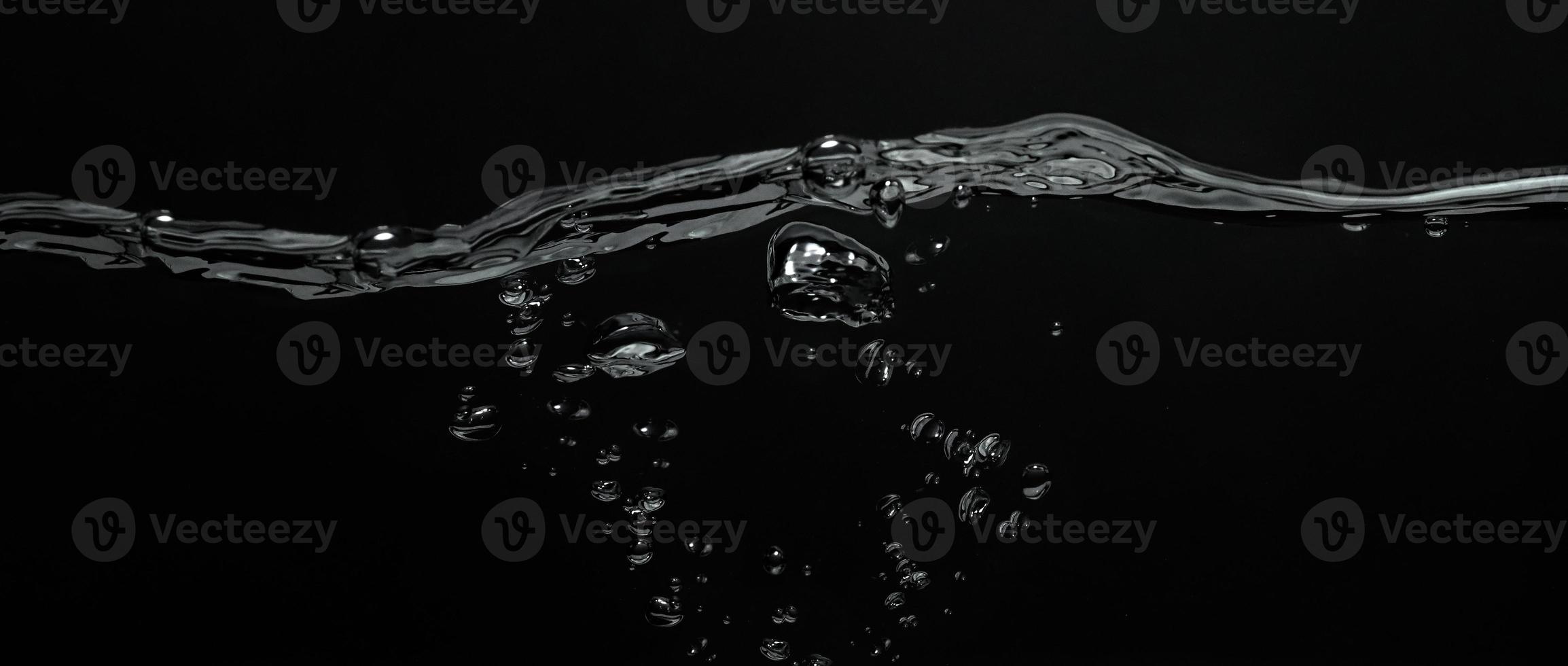 Close up soda water bubbles floating up to top of water surface. photo