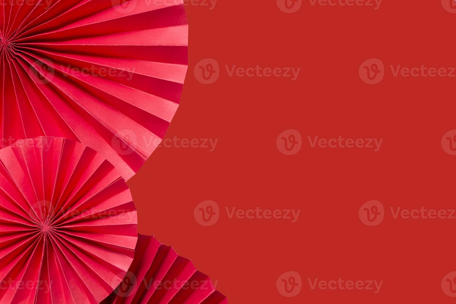 Red paper fans on a red monochrome background copy space. photo