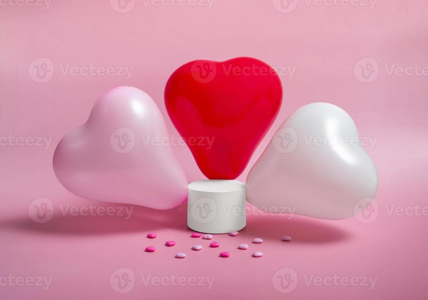 podio con globos en forma de corazón sobre un fondo rosa. día de san valentín foto