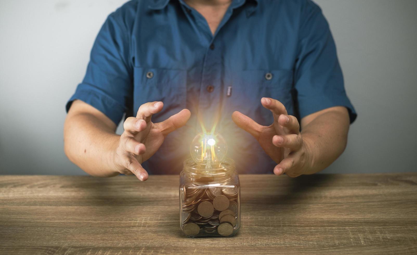 hombre poniendo dinero en el banco frasco para ahorrar para futuras compras de vivienda. planificación de ahorro de dinero, negocios, finanzas, pautas de pago, concepto financiero. foto