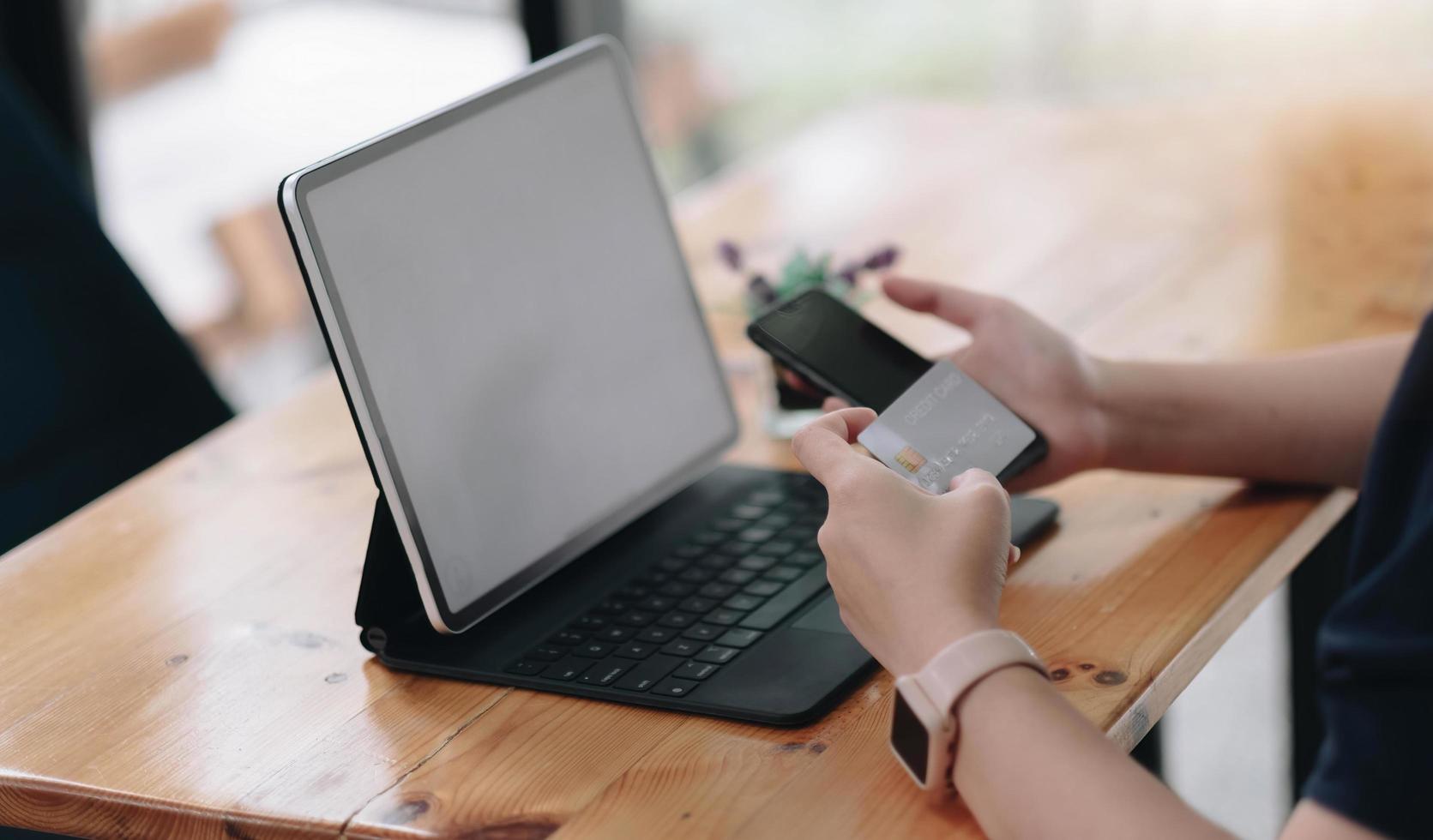 pago en línea, manos de mujeres sosteniendo una tarjeta de crédito y usando un teléfono inteligente y elija algún producto que desee para las compras en línea. foto