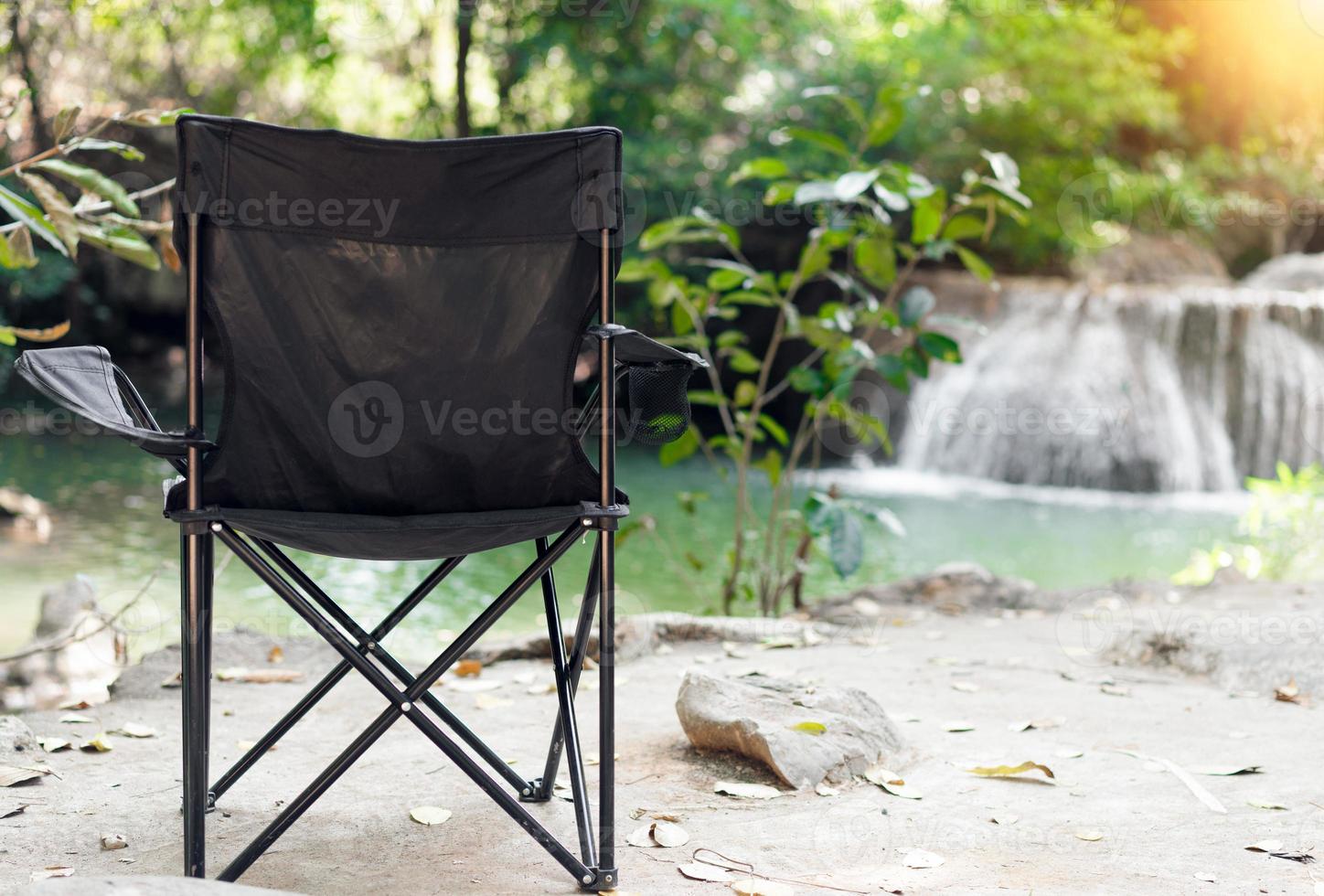 Empty Camping Chair with waterfalls background.  Relax time photo
