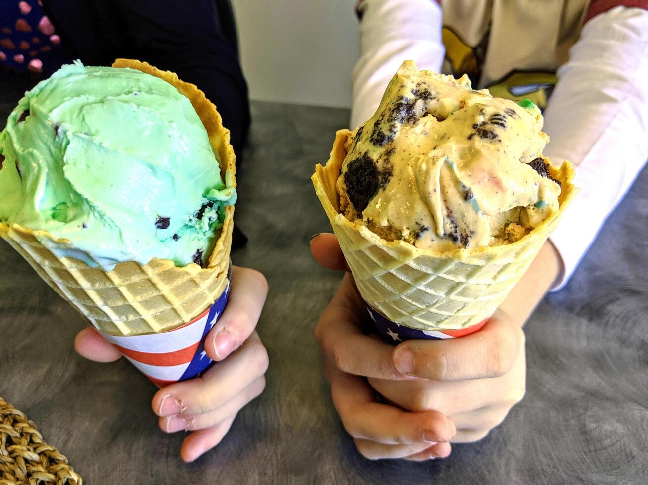 patrón de postre helado de sabor helado en taza blanca mano sujetando sobre la mesa. foto