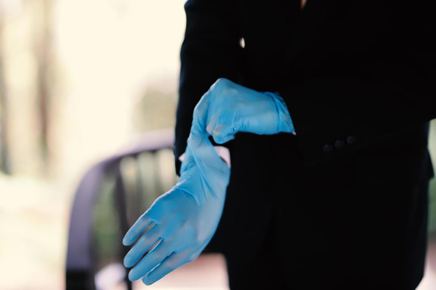 The hands of a man wearing blue gloves preparing for an event photo