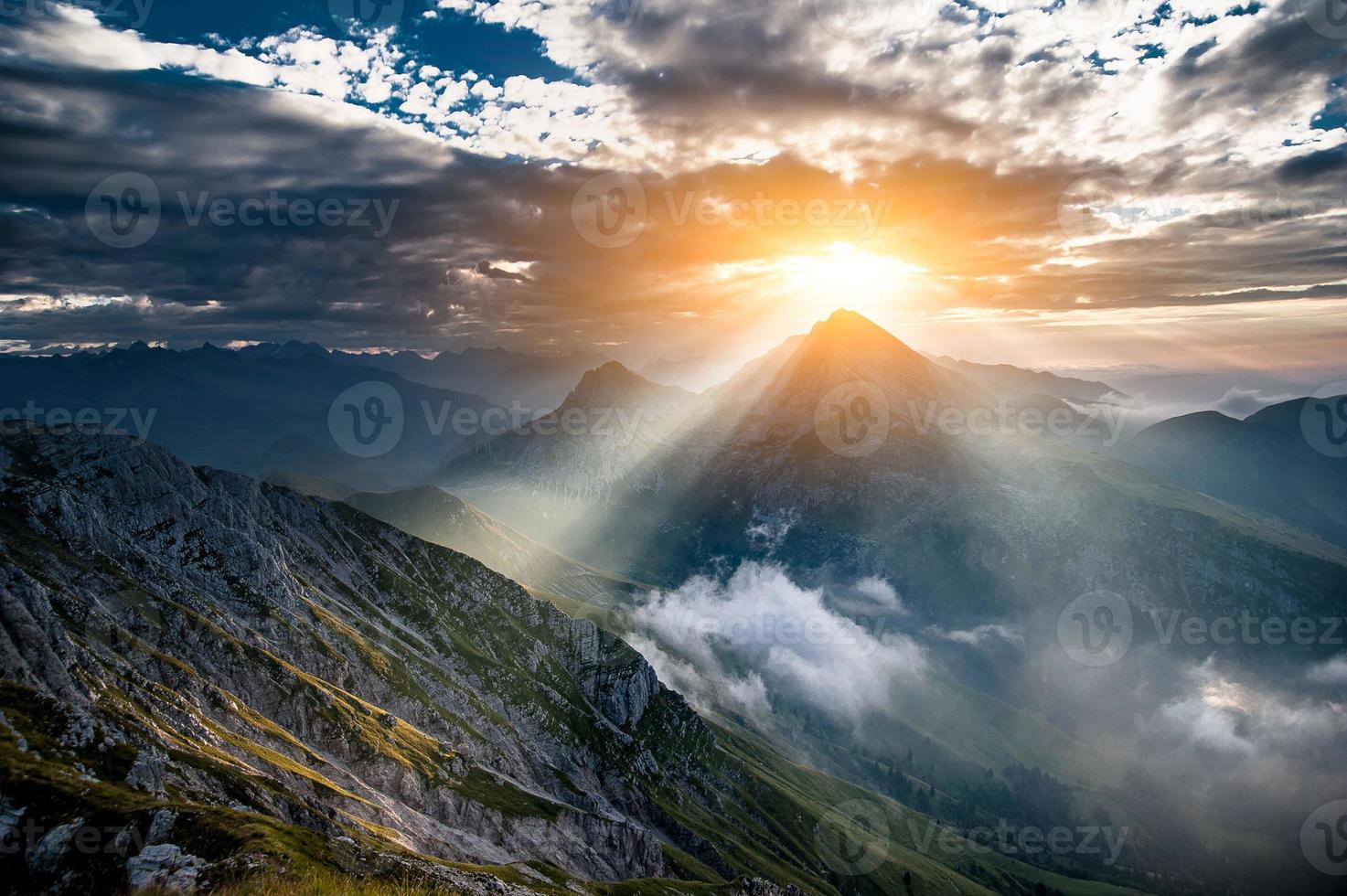 The sun rising behind the mountain photo