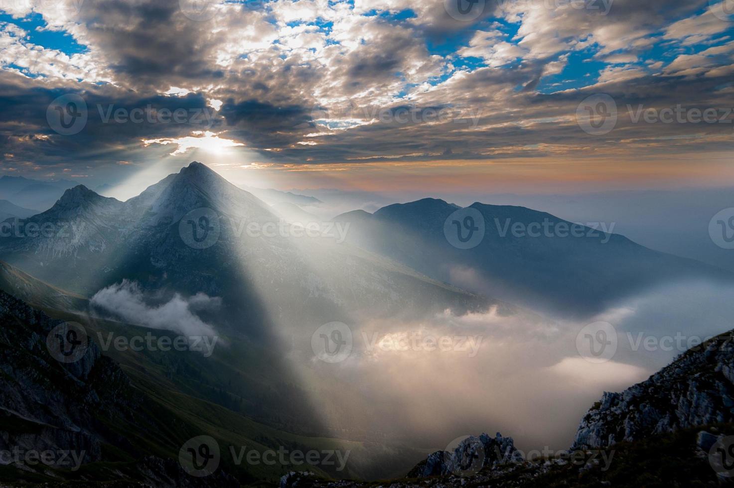 The sun rising behind the mountain photo