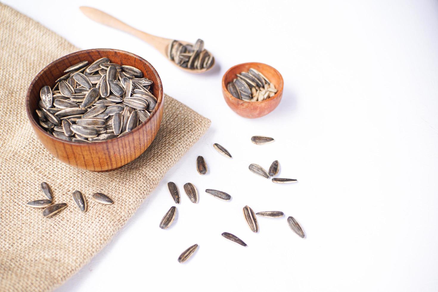 Sunflower seeds in a wooden bowl on a white table photo