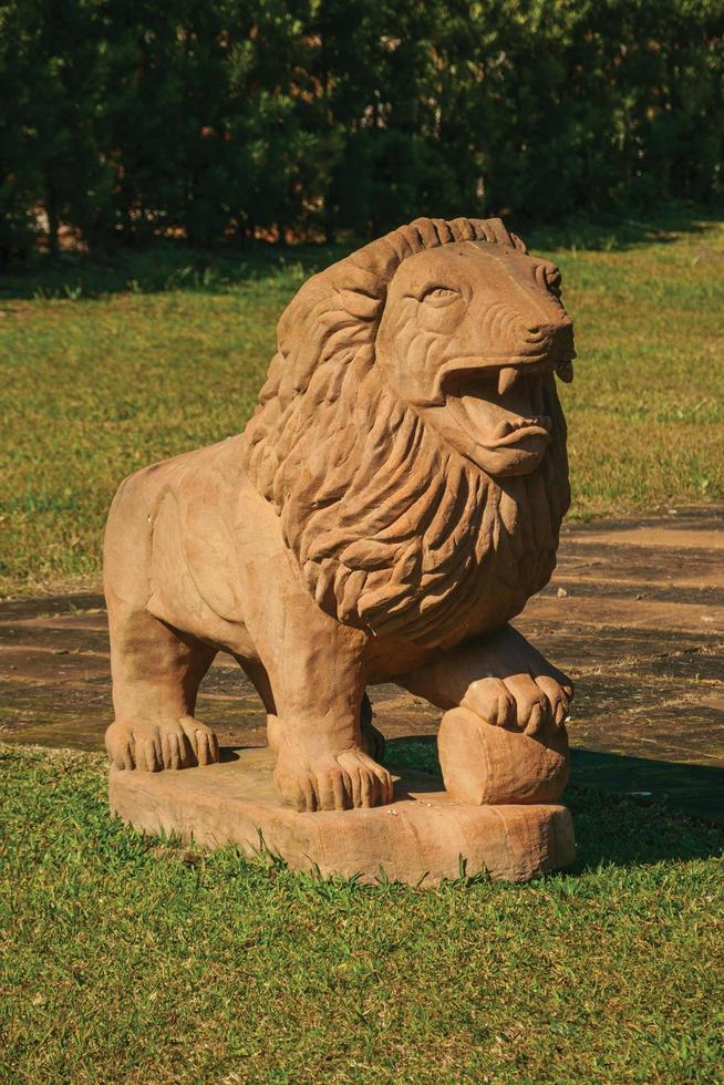 nova petropolis, brasil - 20 de julio de 2019. escultura de piedra arenisca de un león en un césped verde en el parque de esculturas piedras del silencio cerca de nova petropolis. una hermosa ciudad rural fundada por inmigrantes alemanes. foto