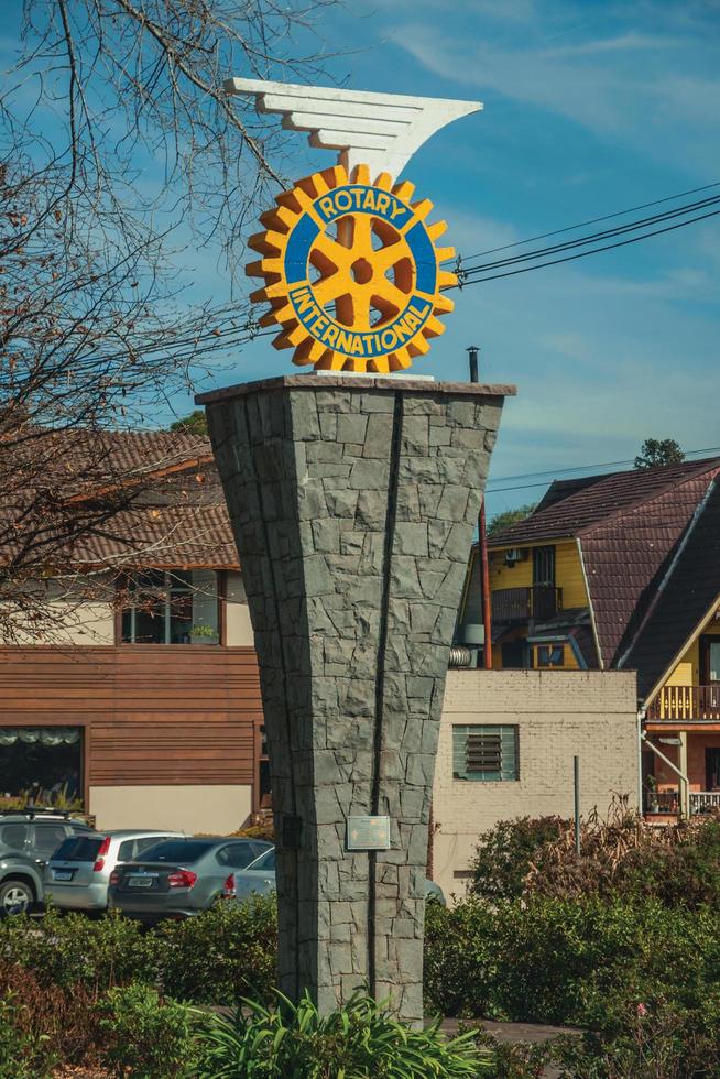 Gramado, Brazil - July 21, 2019. Rotary International logo sculpture on stone pedestal in sunny day at Gramado. A cute european-influenced town highly sought after by tourists. photo