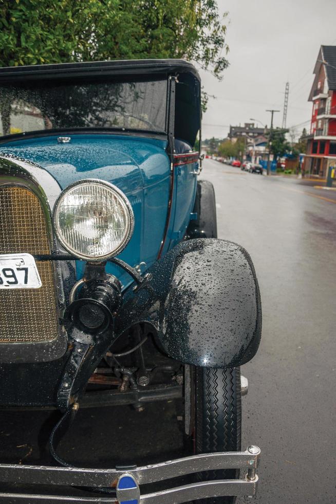 gramado, brasil - 23 de julio de 2019. detalle de faro en coche ford 1929 antiguo en perfecto estado, estacionado en un día lluvioso en una calle de canela. un pequeño pueblo encantador muy popular por su ecoturismo. foto