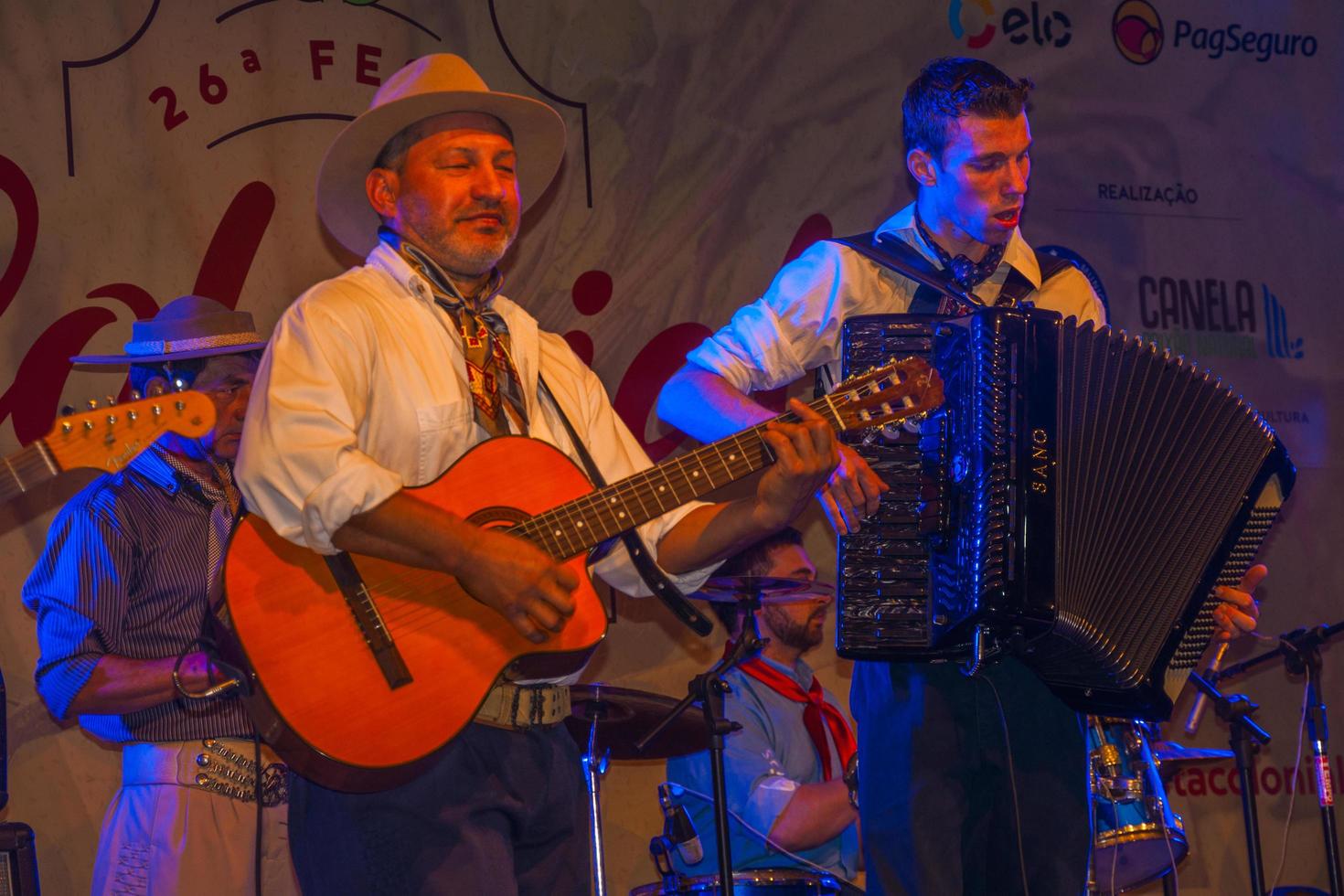 canela, brasil - 21 de julio de 2019. músicos vestidos con ropas típicas interpretando canciones tradicionales en el escenario de un festival folclórico en canela. un pequeño pueblo encantador muy popular por su ecoturismo. foto