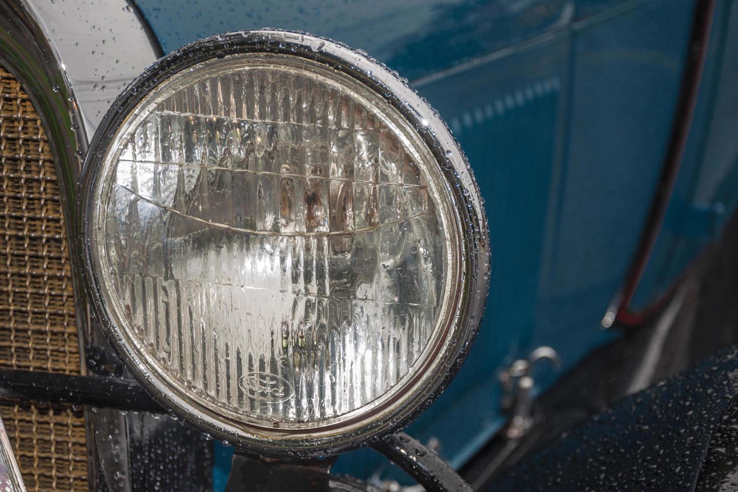 gramado, brasil - 23 de julio de 2019. detalle de faro en coche ford 1929 antiguo en perfecto estado, estacionado en un día lluvioso en una calle de canela. un pequeño pueblo encantador muy popular por su ecoturismo. foto