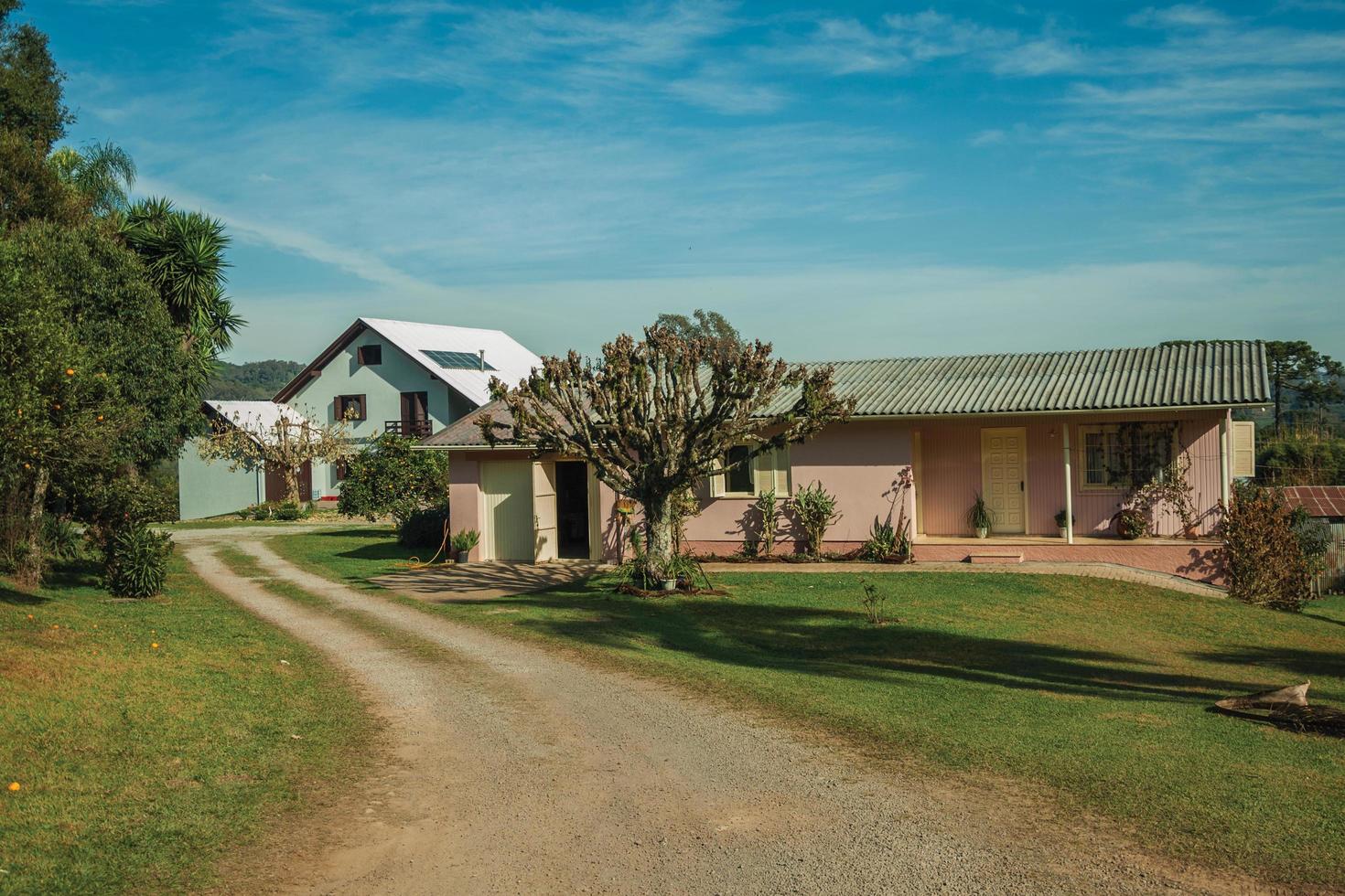 bento goncalves, brasil - 12 de julio de 2019. encantadora casa de campo moderna con camino y un exuberante jardín, en un paisaje rural cerca de bento goncalves. foto