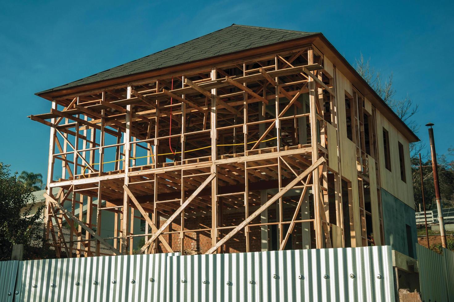 Bento Goncalves, Brazil - July 12, 2019. Construction site with wooden house being built and metal siding, in the countryside near Bento Goncalves. photo