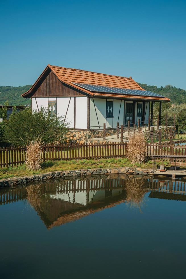 Nova Petropolis, Brazil - July 20, 2019. House in German-influenced style with pond amid rural landscape in the Sculpture Park Stones of Silence near Nova Petropolis. photo