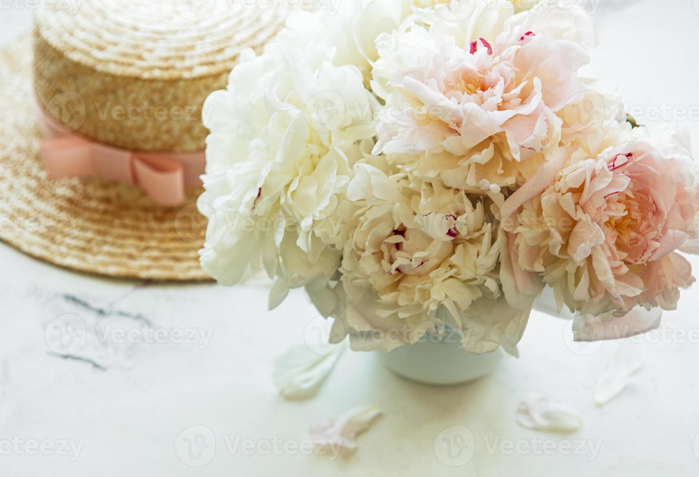 Straw hat and peonies photo