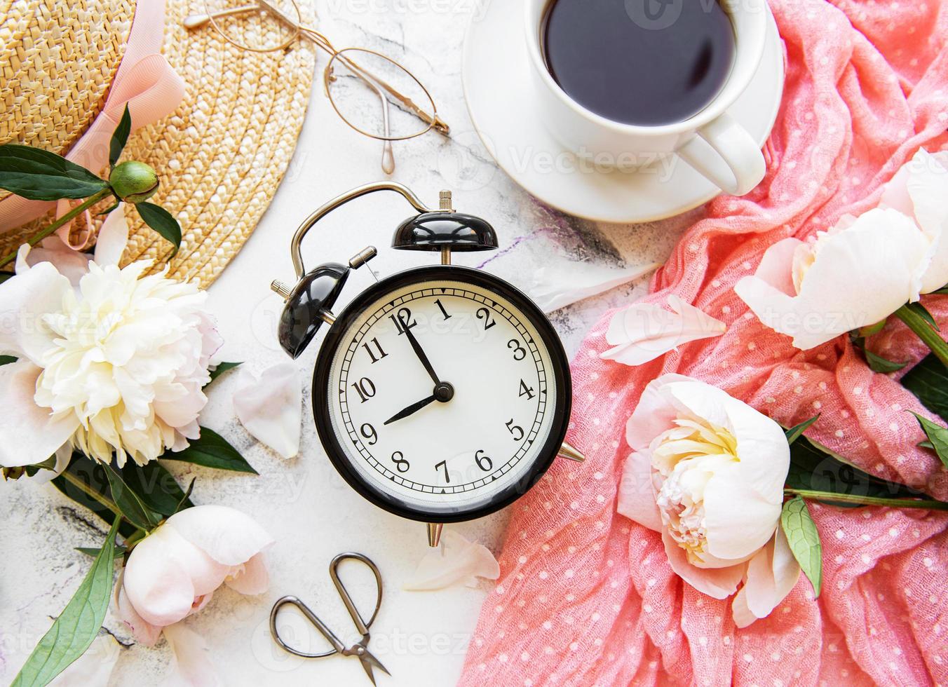 Alarm clock, tea and peonies photo