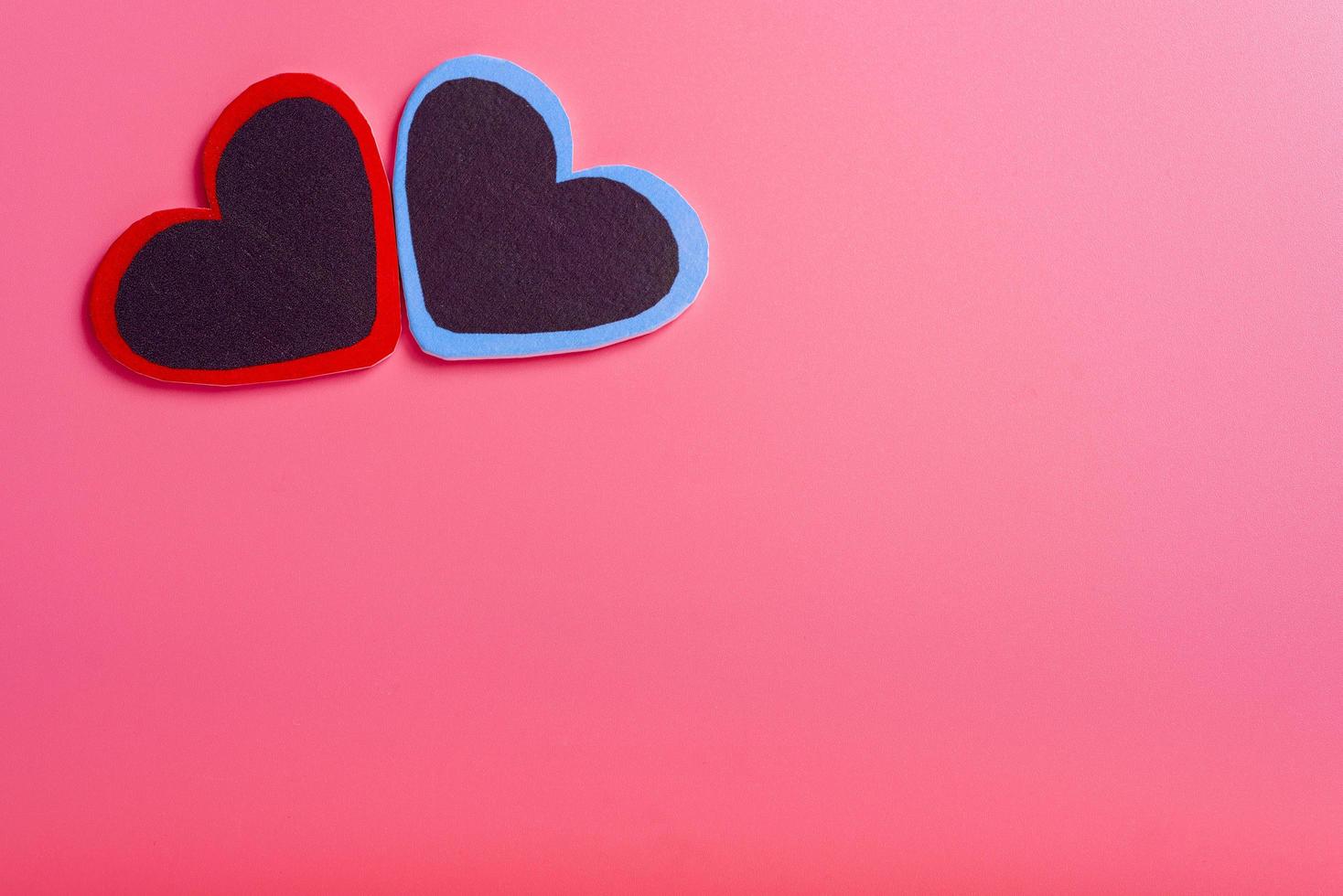 Two hearts on a pink background in the upper left corner. The concept of Valentine's day. photo