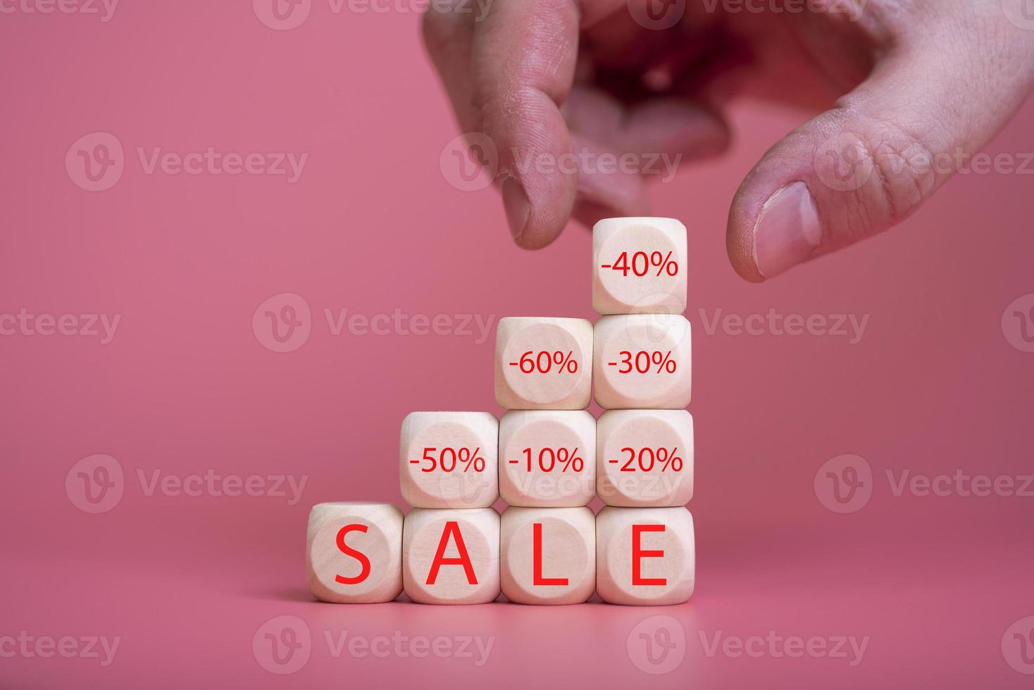 Wooden cubes on a pink background, on them the word SALE is written photo