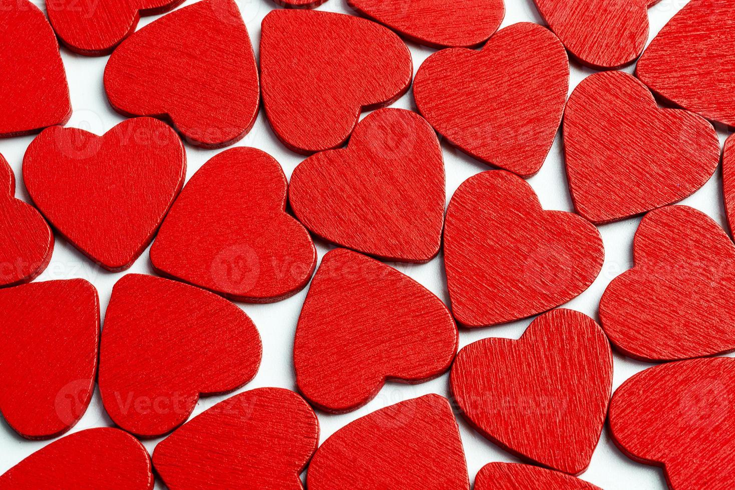 A lot of red hearts lying on the white background. photo