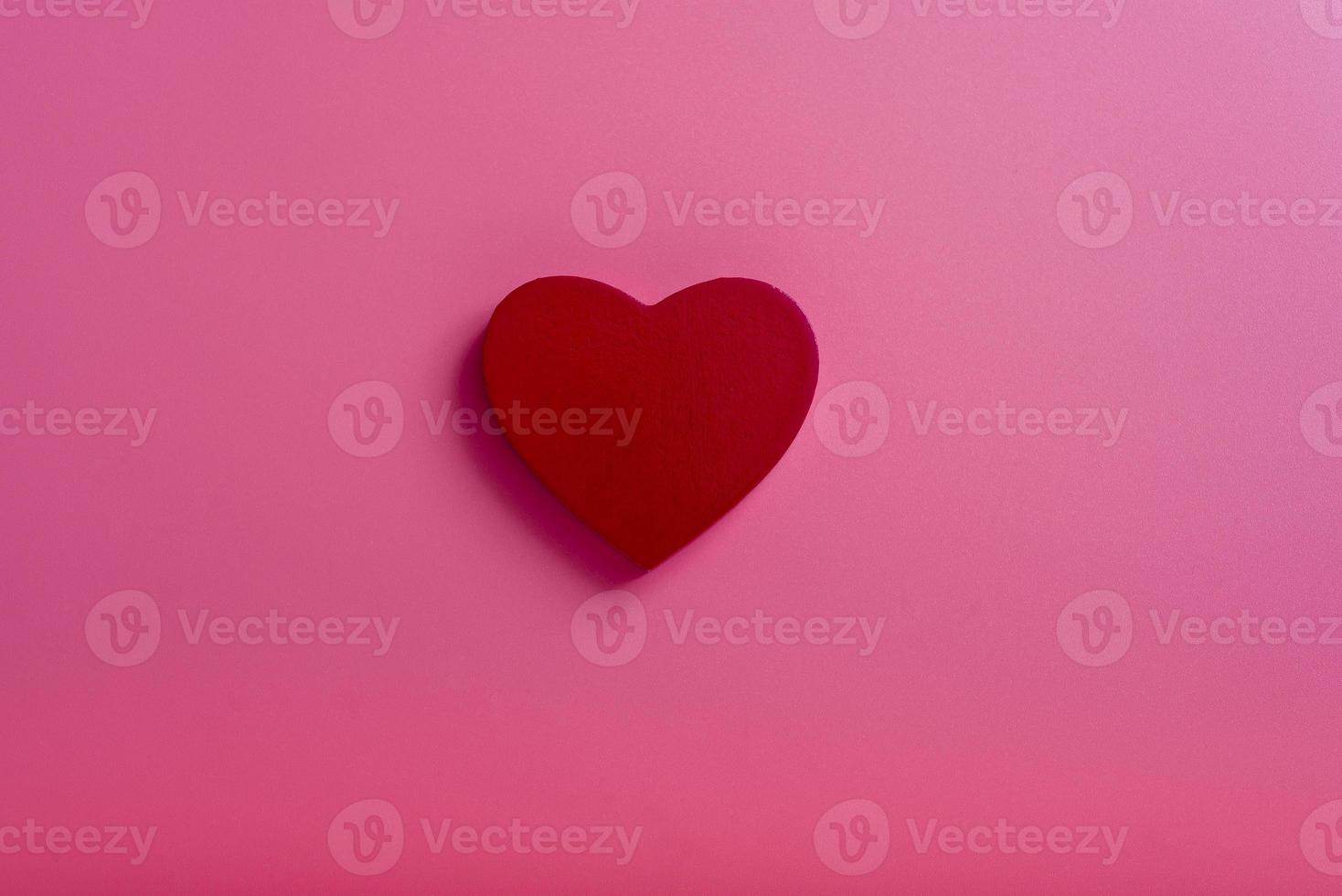 corazón sobre un fondo rosa en el medio. el concepto del día de san valentín. foto