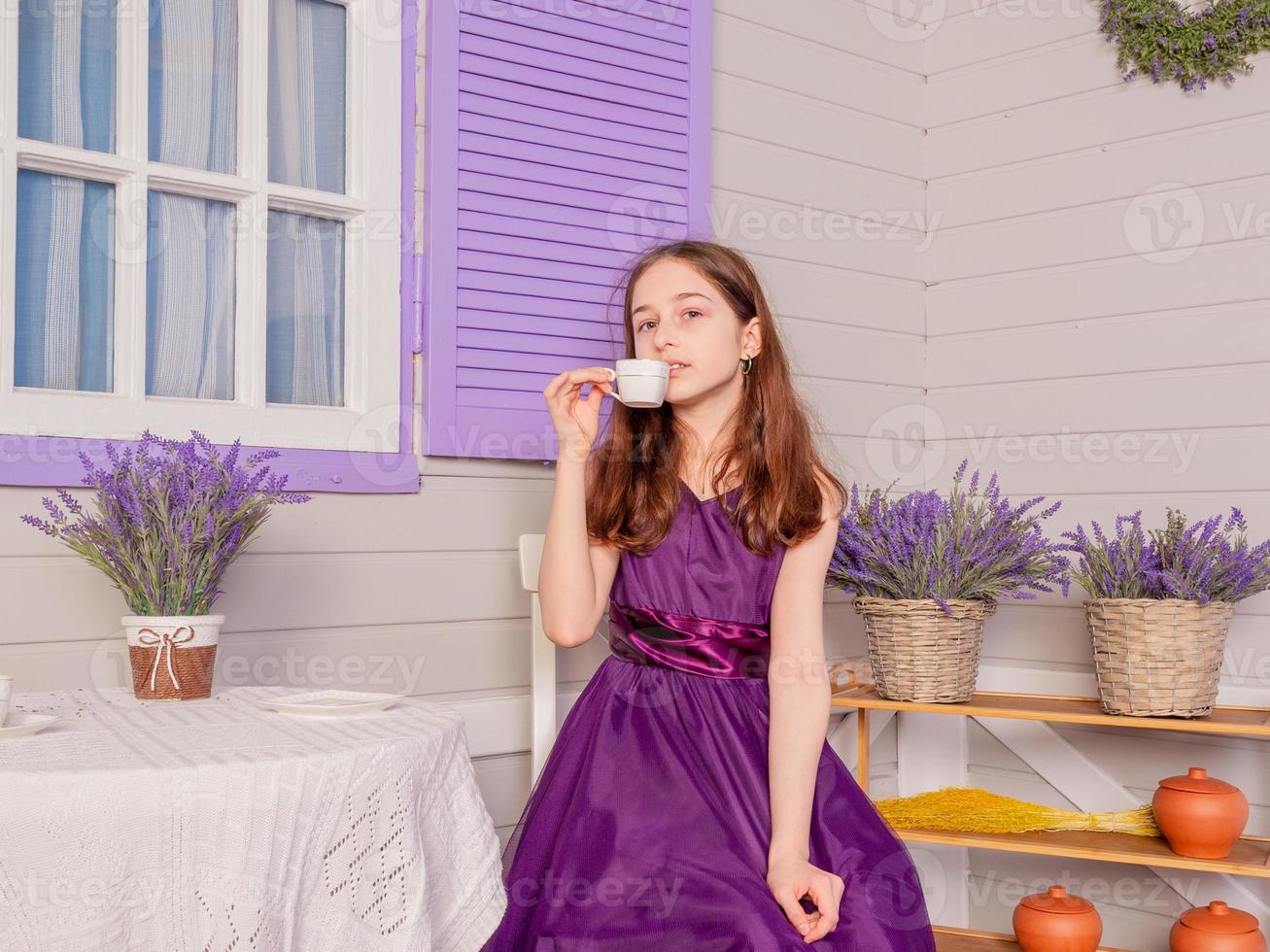 una adolescente con un vestido morado bebe té en una taza blanca. la niña está sentada a la mesa. 4924626 Foto de stock en Vecteezy una adolescente con un vestido morado bebe té en una taza blanca. la niña está sentada a la mesa. 4924626 Foto de stock en Vecteezy