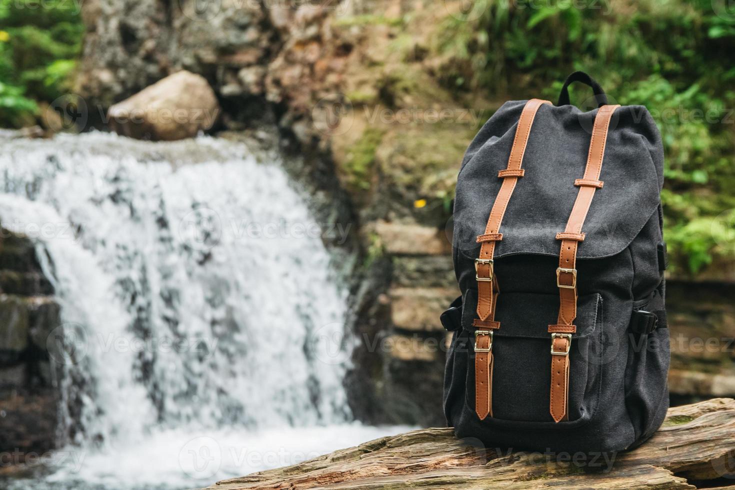 Turismo de mochila en el fondo del río y la cascada. foto