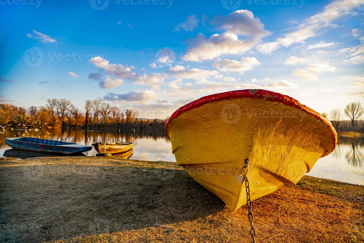 Viejo barco amarillo en el suelo junto al lago foto