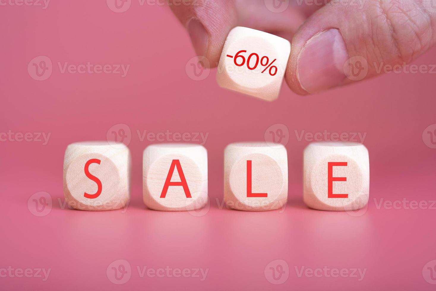 Wooden cubes on a pink background, on them the word SALE is written photo