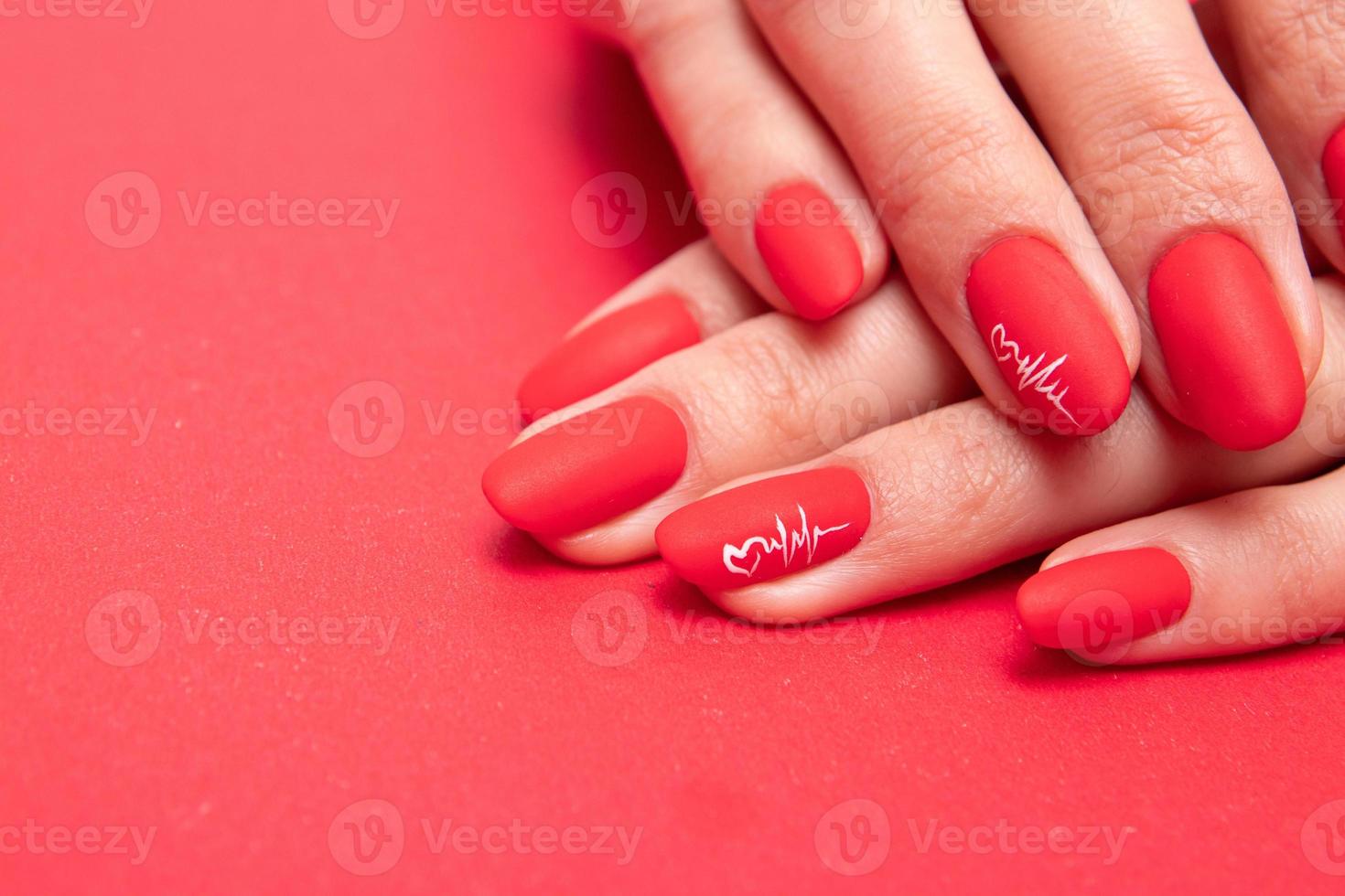 Red matte manicure on female hands for valentines day photo