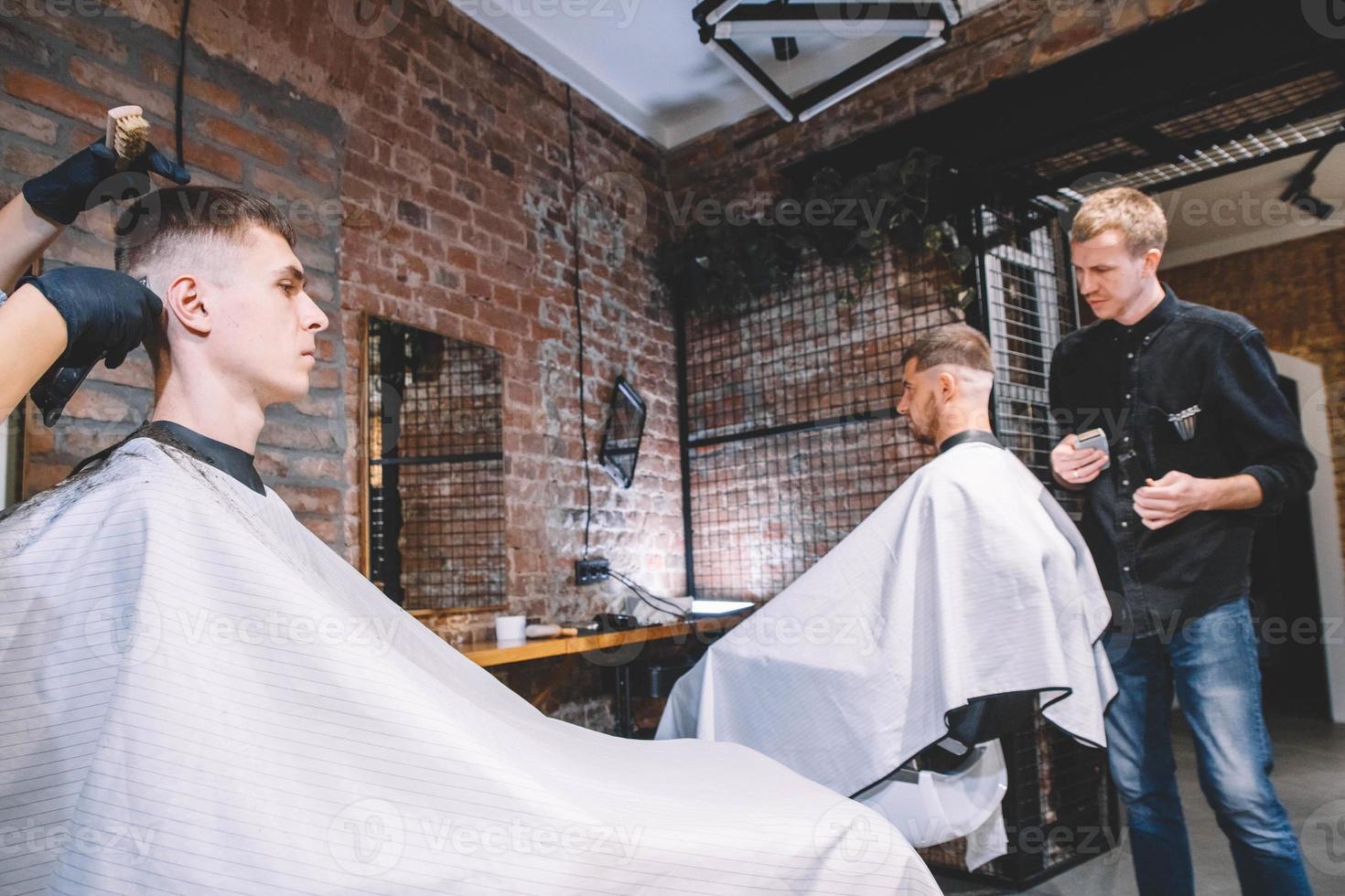 Hairdressers cut their clients in barbershop. Advertising and barber shop concept photo