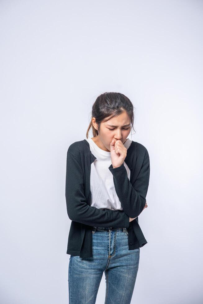 A woman coughing and covering her mouth with her hand photo