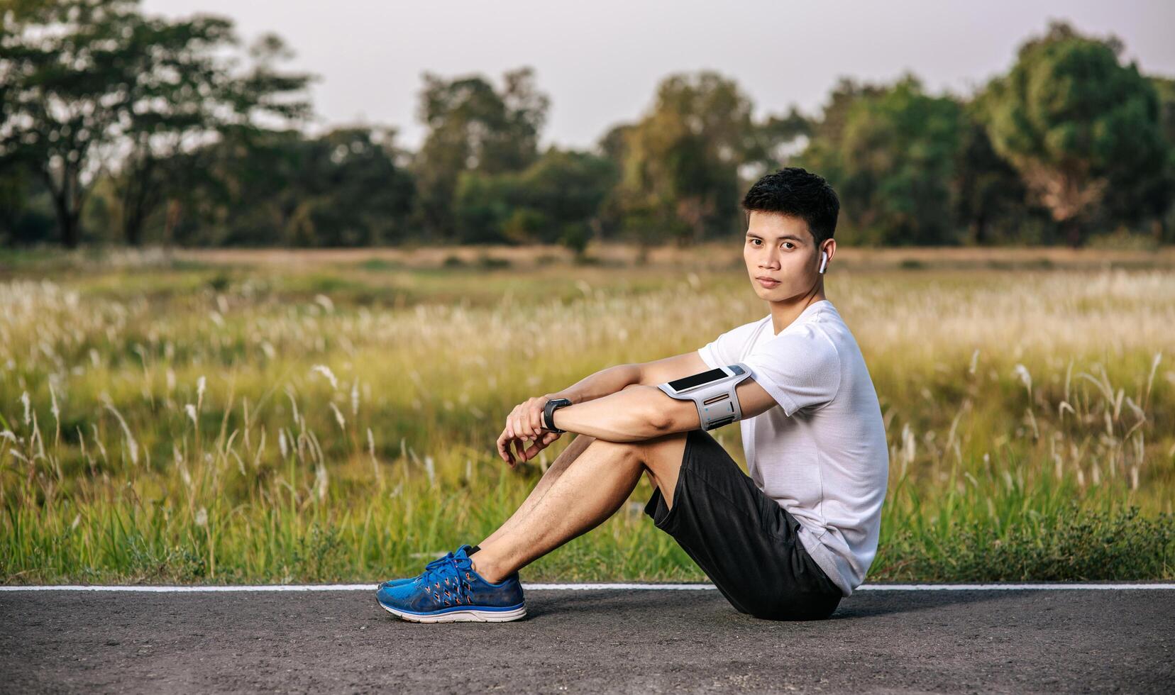 Men sitting and resting after exercising on the roadside. photo