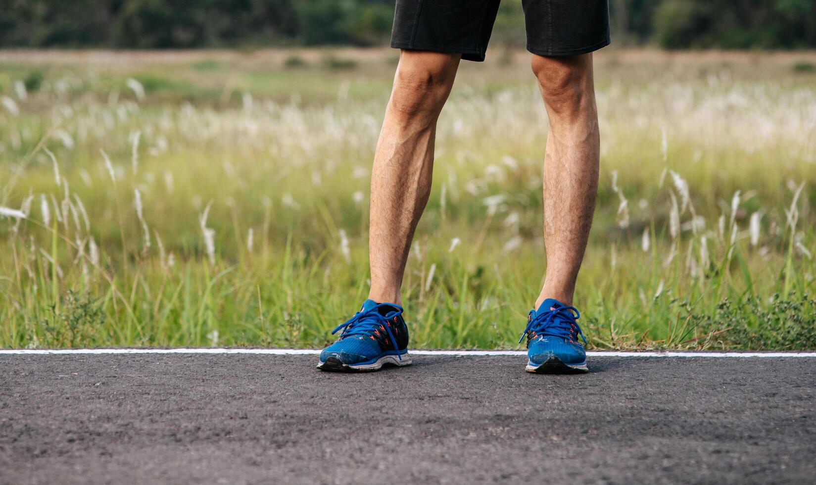 Runner man feet running on road closeup on shoe. Sports healthy lifestyle concept. photo