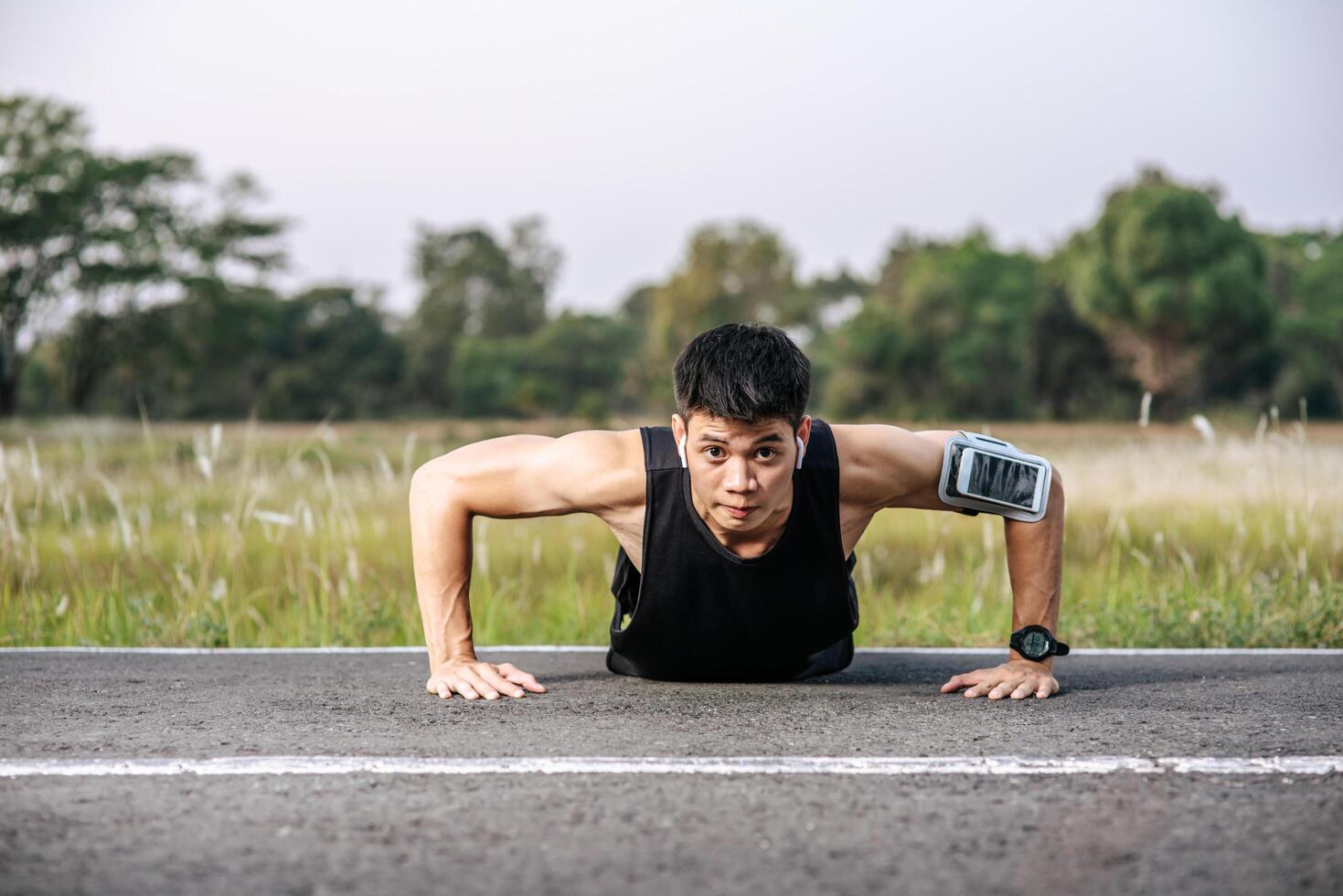 Men wear black shirts with muscles push up on the street. photo