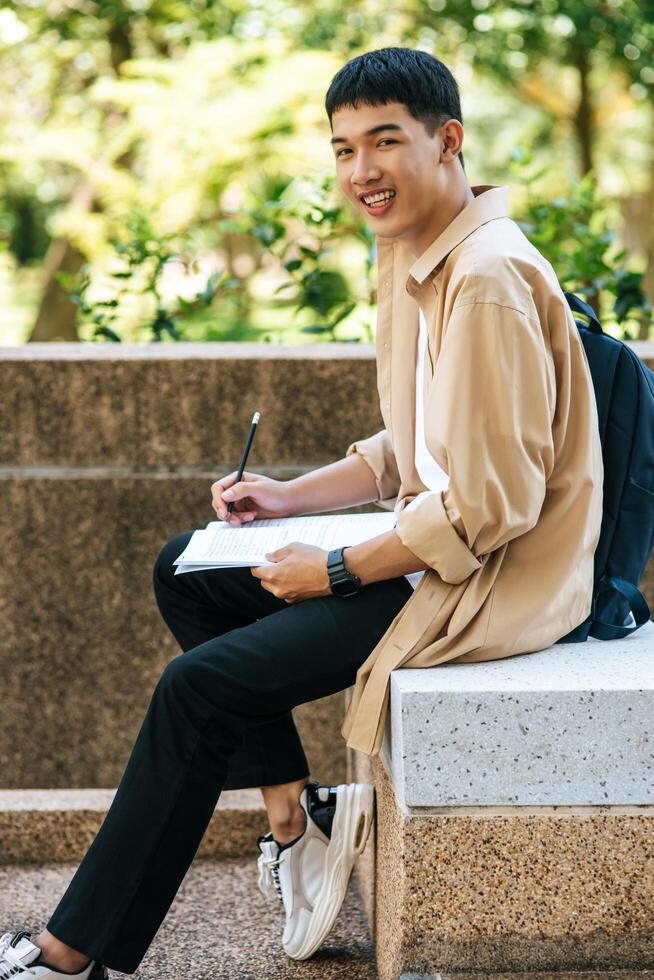 A man sitting and reading a book on the stairs. photo