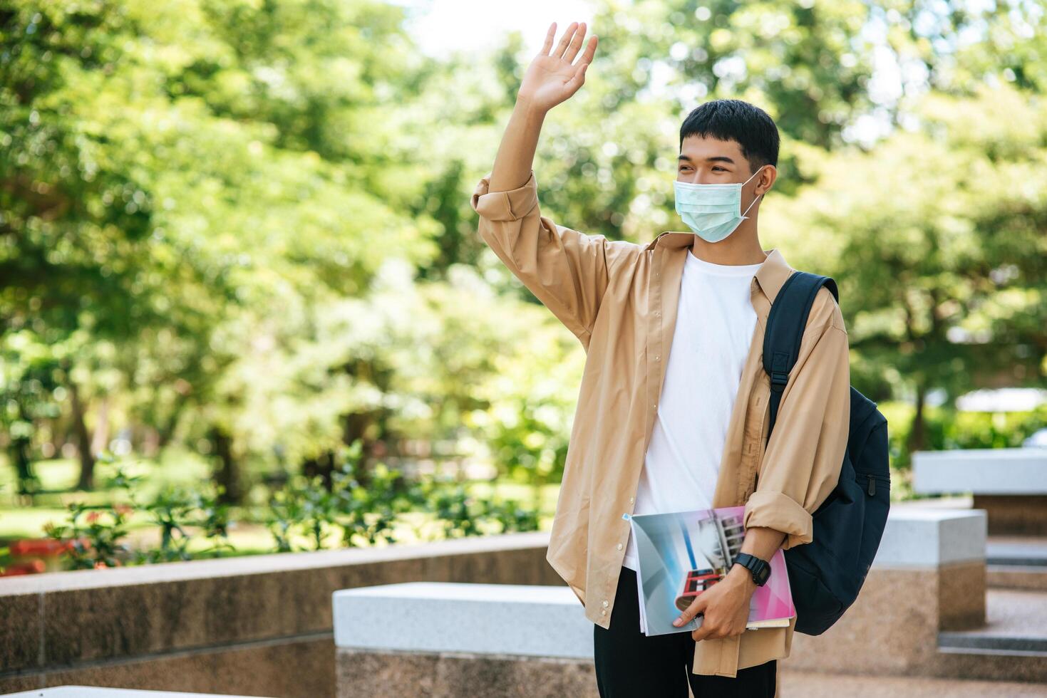 Men wear masks, carry books, and carry a backpack on the stairs. photo