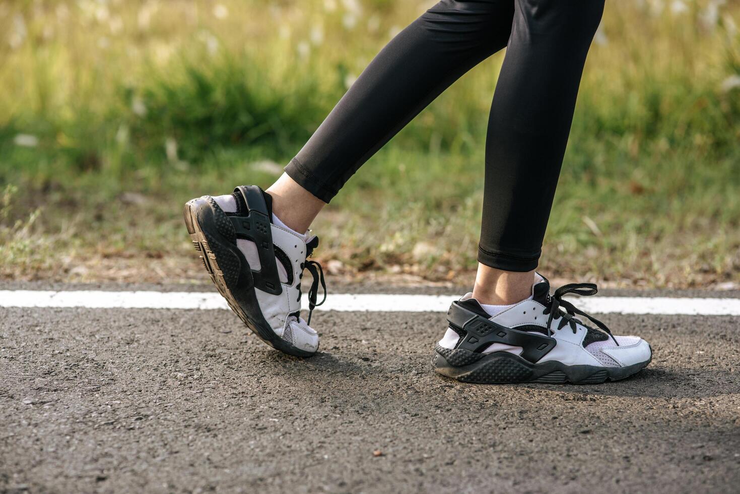 Runner woman feet running on road closeup on shoe. Sports healthy lifestyle concept. photo