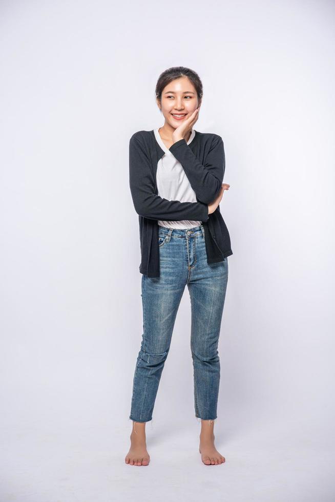 A smiling woman happily in a black shirt, standing jeans, smiling happily. photo