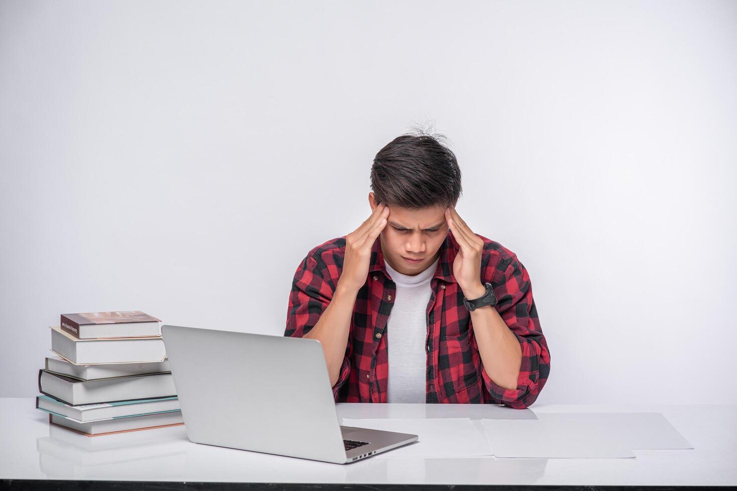 Men use laptops in the office and are stressed. photo